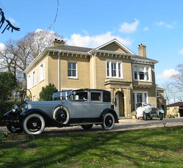 white Rolls Royce parked in front of Winslowe House on a bright and sunny day